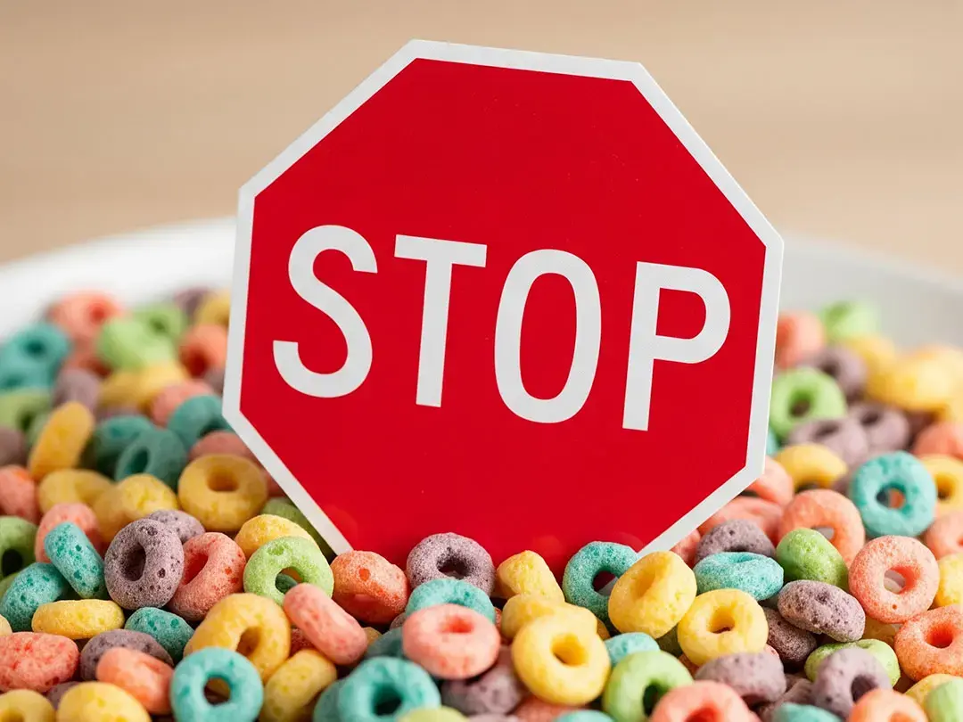Red stop sign standing among colorful cereal rings